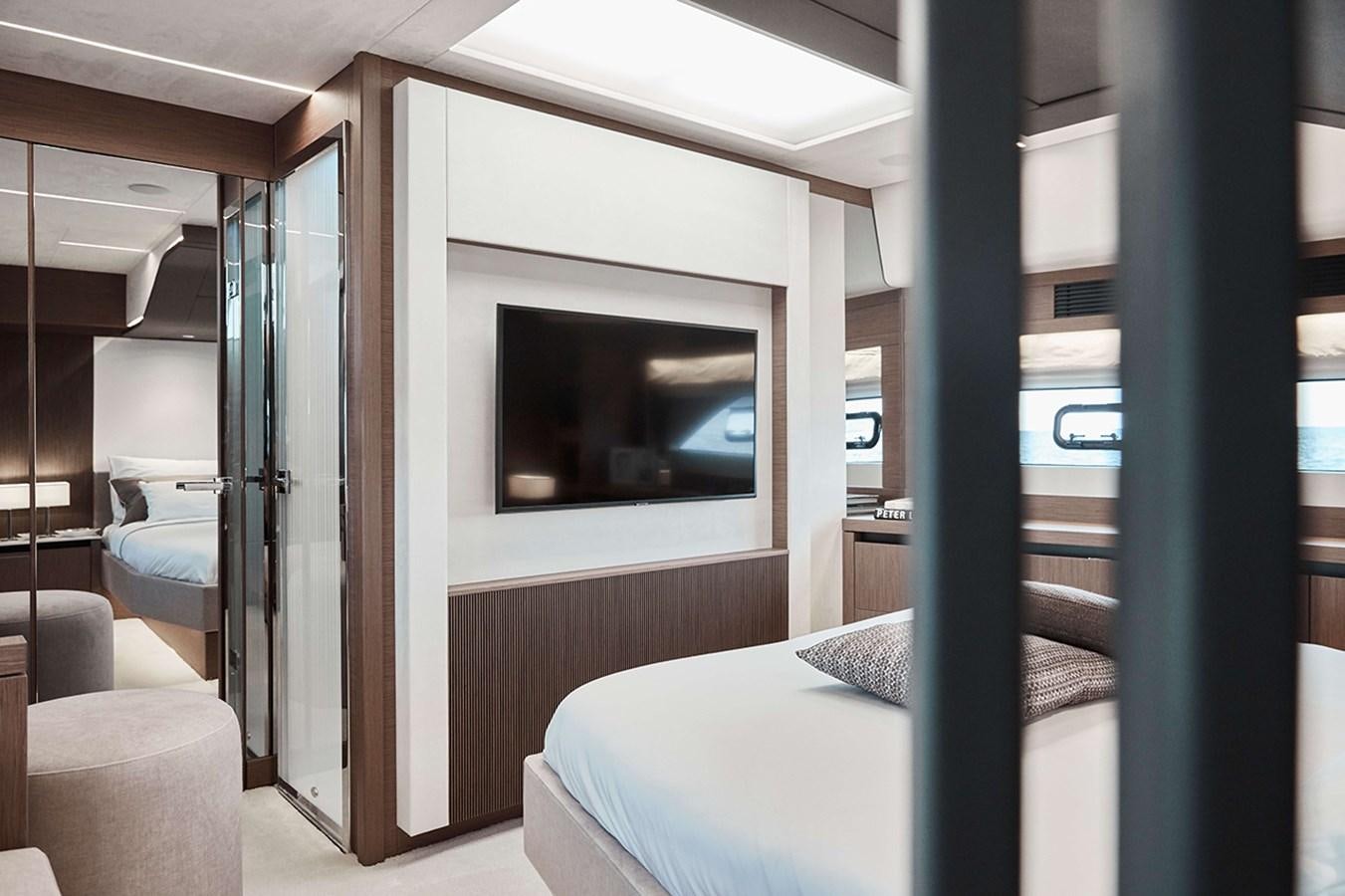 a room with a bed and a television aboard 2022 PRESTIGE X70 #09 Yacht for Sale