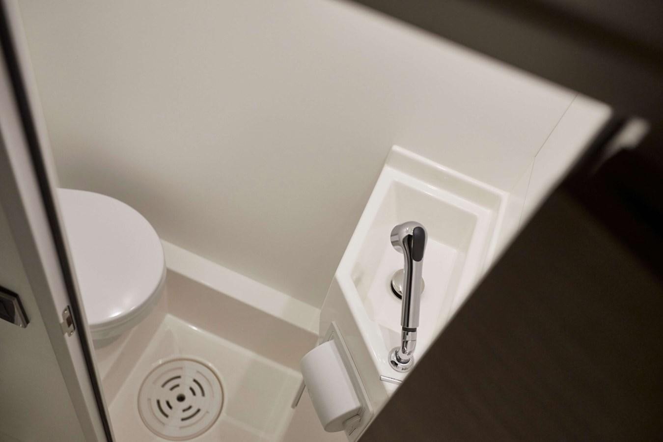 a white toilet with a handle aboard 2022 PRESTIGE X70 #09 Yacht for Sale