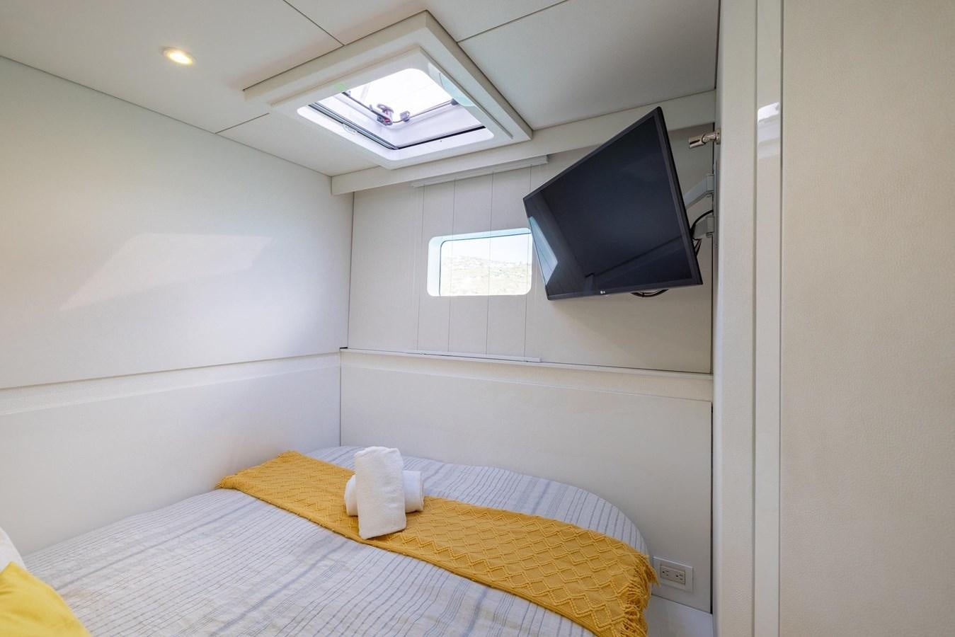 a bed with a television on the wall aboard VALHALLA Yacht for Sale
