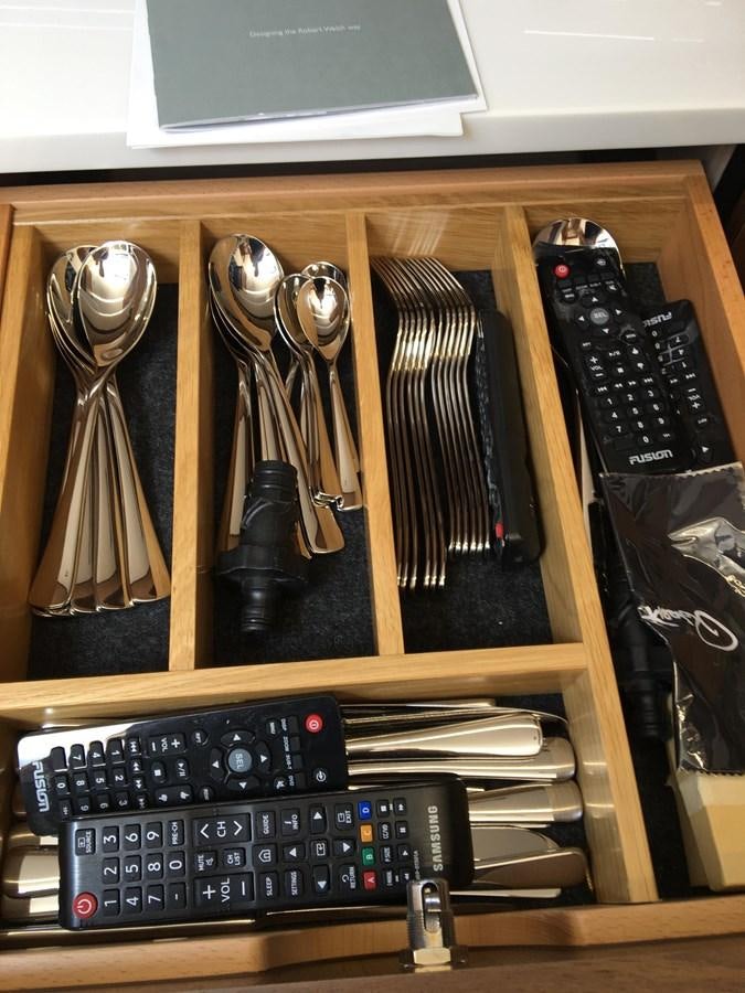 a shelf with a remote and a television aboard LYDIA SWAG Yacht for Sale