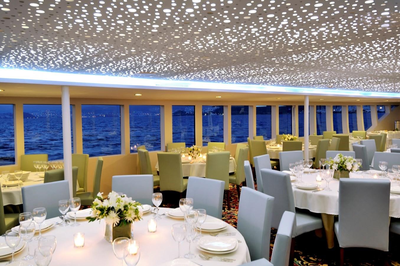 a room with tables and chairs aboard 2011 CUSTOM PASSENGER CRUISE SHIP Yacht for Sale