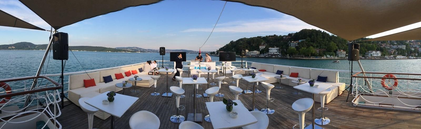 a deck with tables and chairs aboard 2011 CUSTOM PASSENGER CRUISE SHIP Yacht for Sale