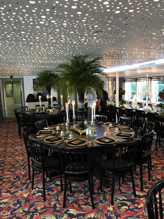 a large room with tables and chairs aboard 2011 CUSTOM PASSENGER CRUISE SHIP Yacht for Sale