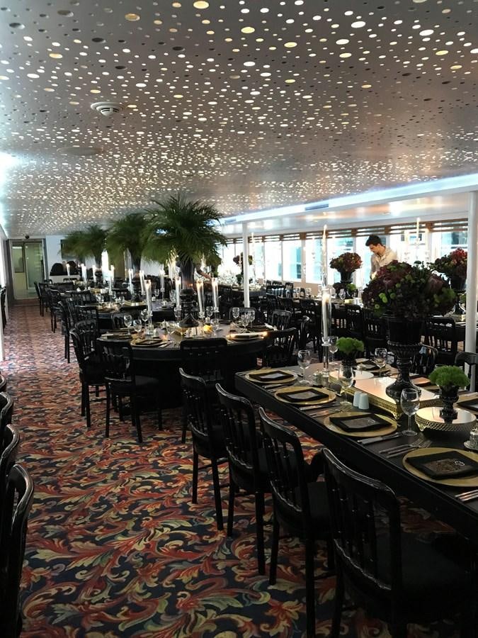 a large room with tables and chairs aboard 2011 CUSTOM PASSENGER CRUISE SHIP Yacht for Sale
