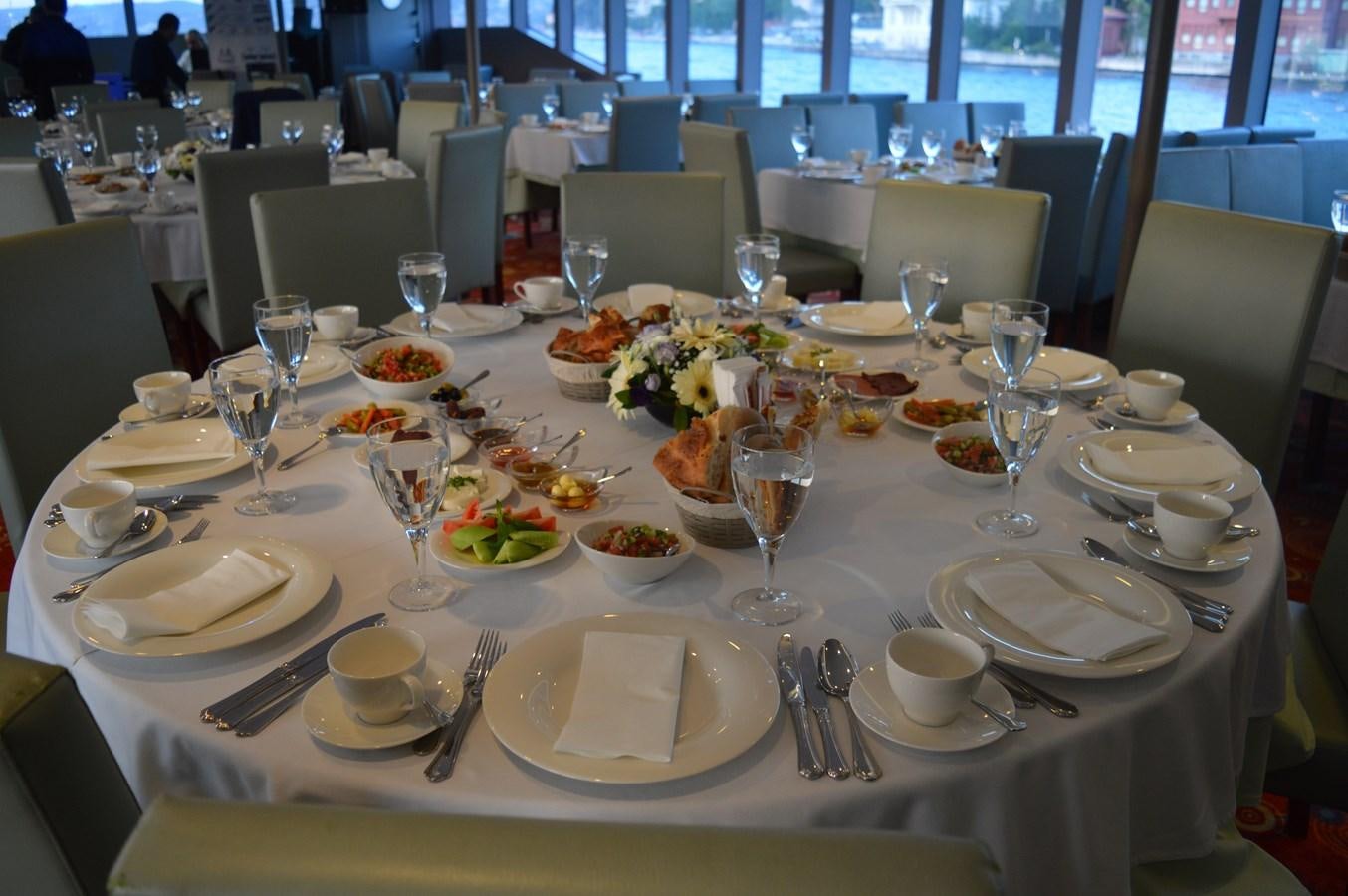 a table set with plates and glasses aboard 2011 CUSTOM PASSENGER CRUISE SHIP Yacht for Sale