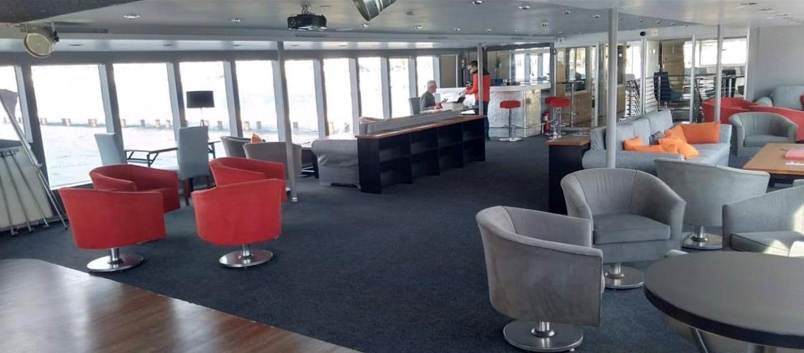 a room with chairs and tables aboard 2011 CUSTOM PASSENGER CRUISE SHIP Yacht for Sale