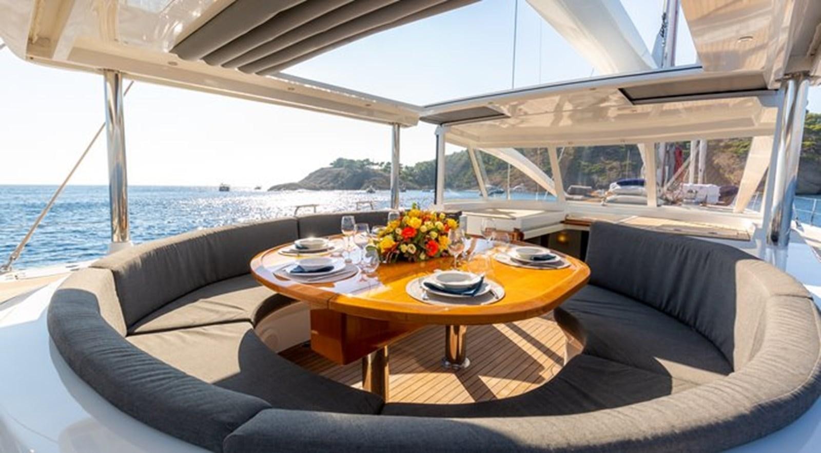 a table with plates and glasses on it aboard SAVARONA Yacht for Sale