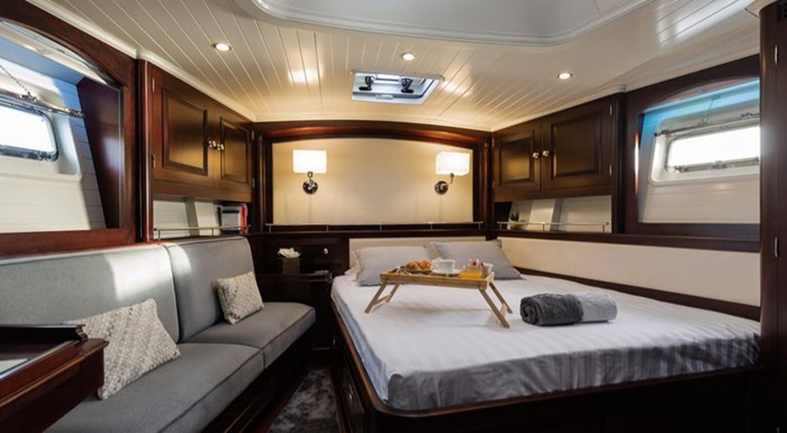 a room with a bed and a couch aboard SAVARONA Yacht for Sale