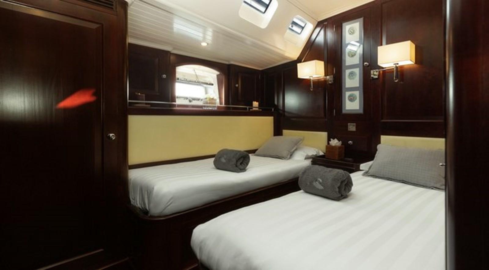 a room with beds and a window aboard SAVARONA Yacht for Sale