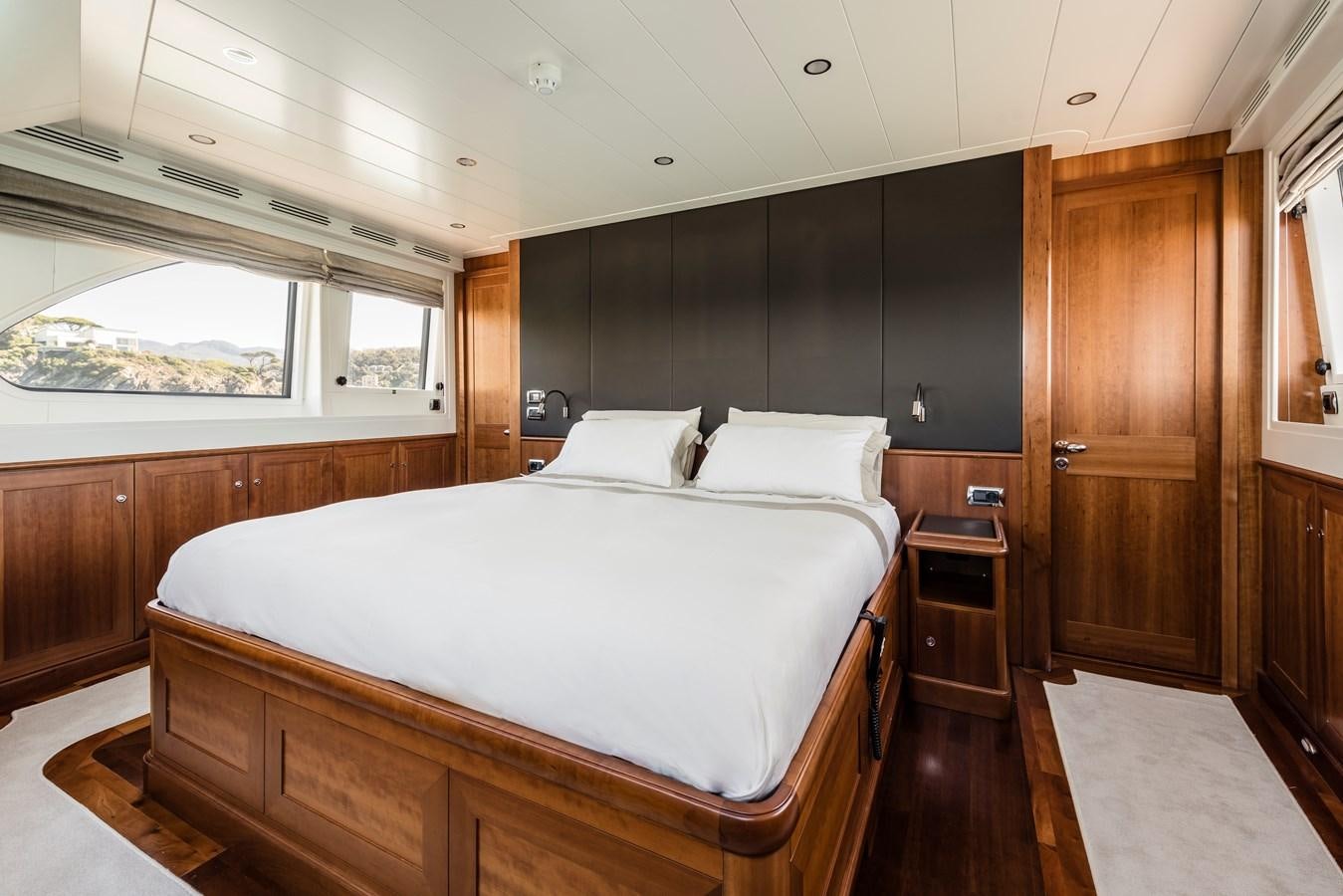 a room with a bed and a wood cabinet aboard ARCHIPELAGO Yacht for Sale
