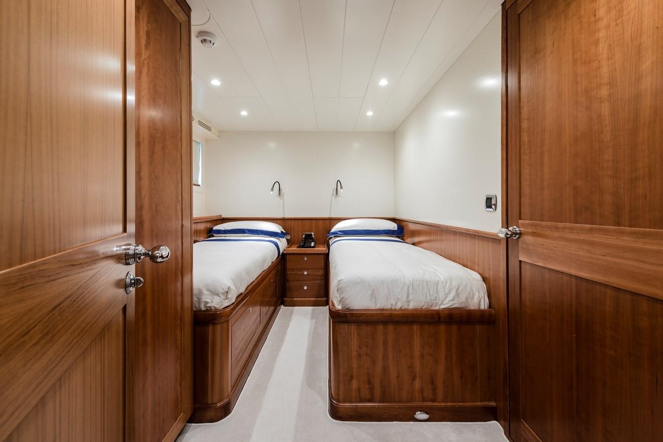 a bedroom with wooden furniture aboard ARCHIPELAGO Yacht for Sale