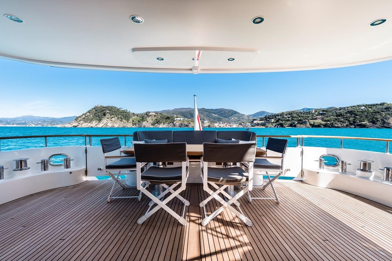 a deck with chairs and tables on it by the water aboard ARCHIPELAGO Yacht for Sale