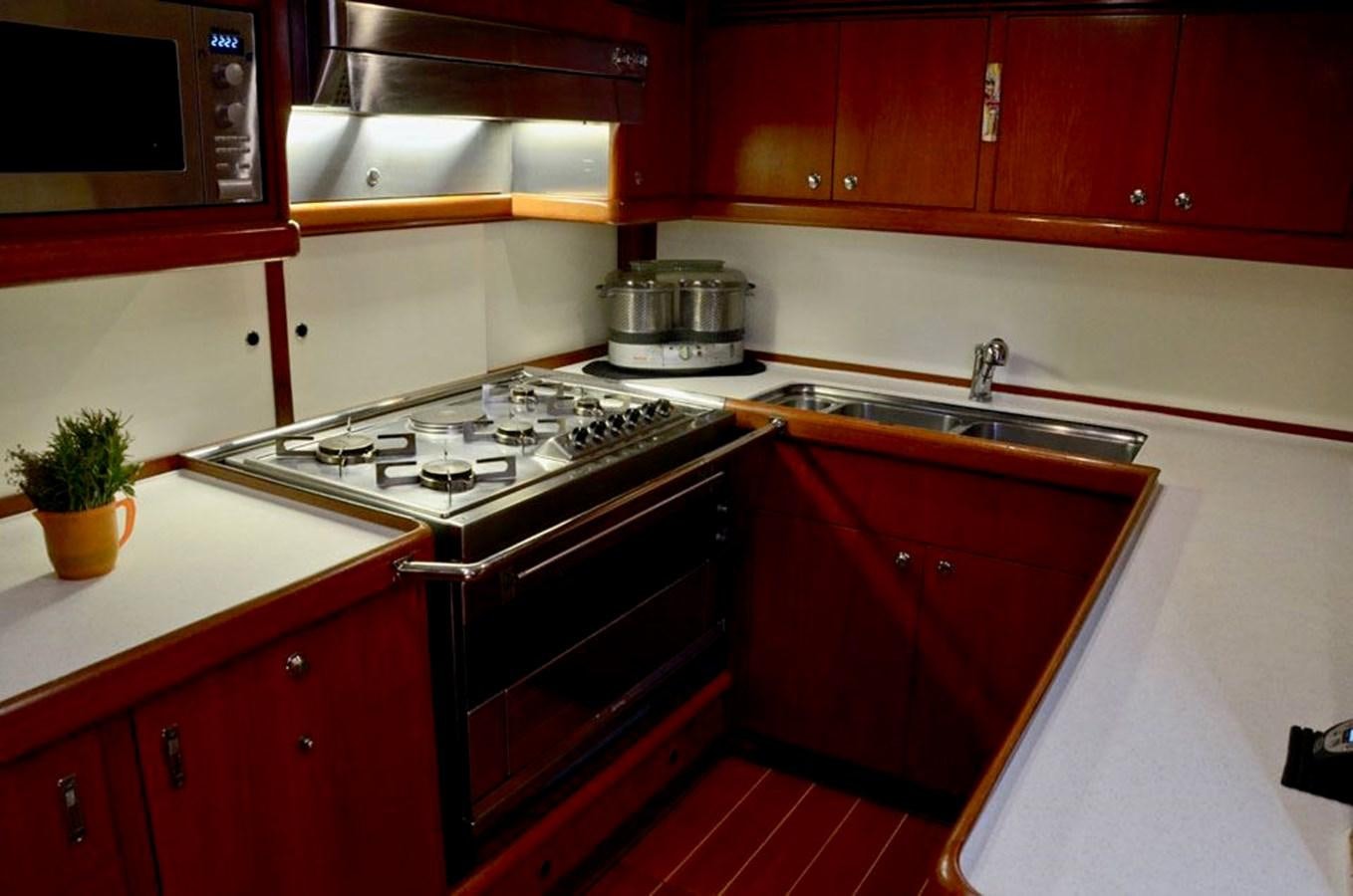 a kitchen with red cabinets aboard STARFALL Yacht for Sale