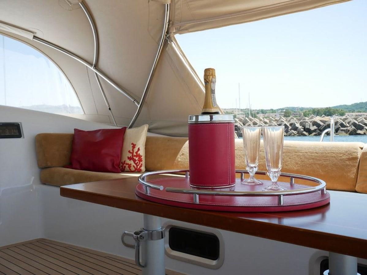 a table with a glass of wine and a bottle of wine aboard STARFALL Yacht for Sale