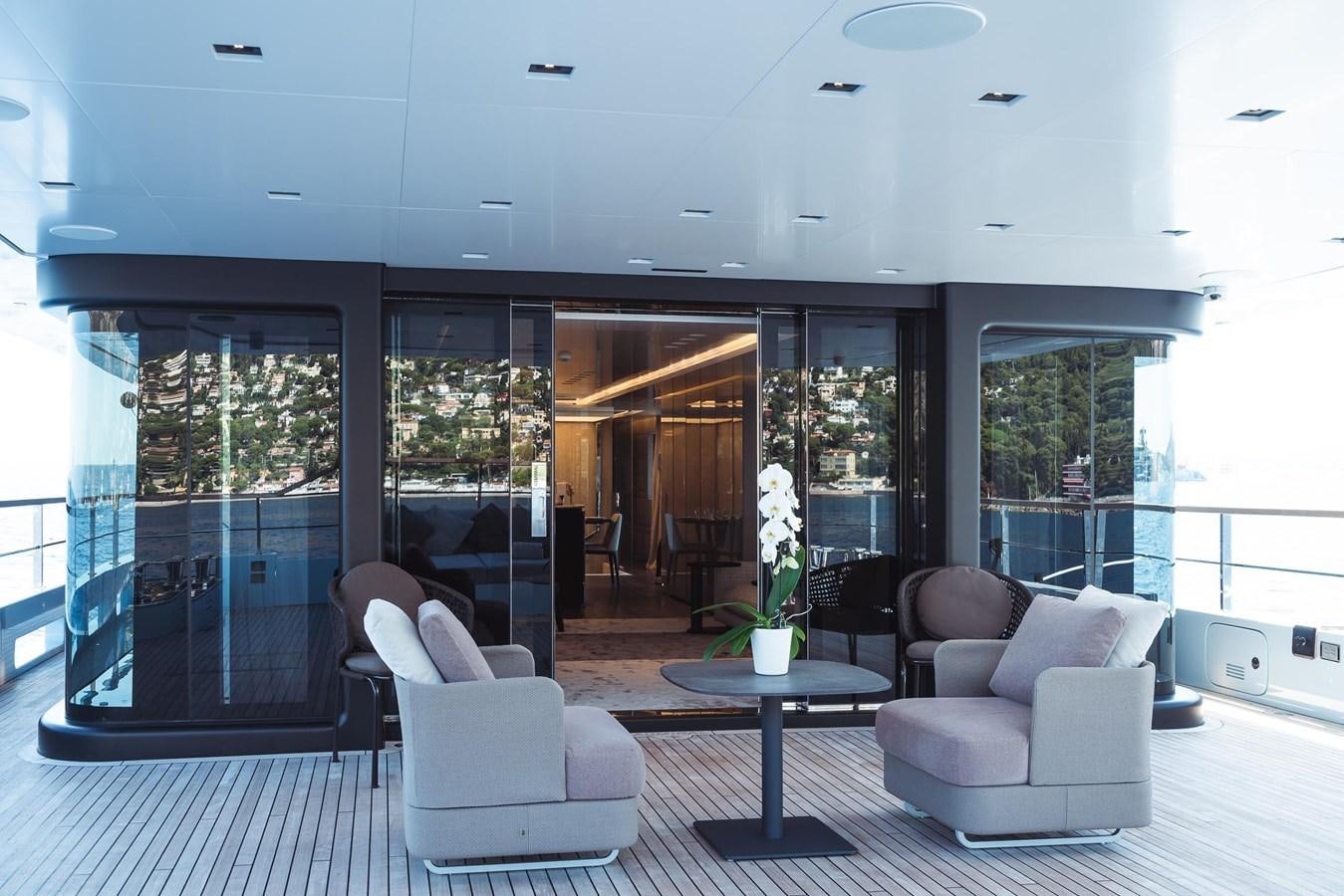 a room with a table chairs and a glass wall aboard JESMA II Yacht for Charter