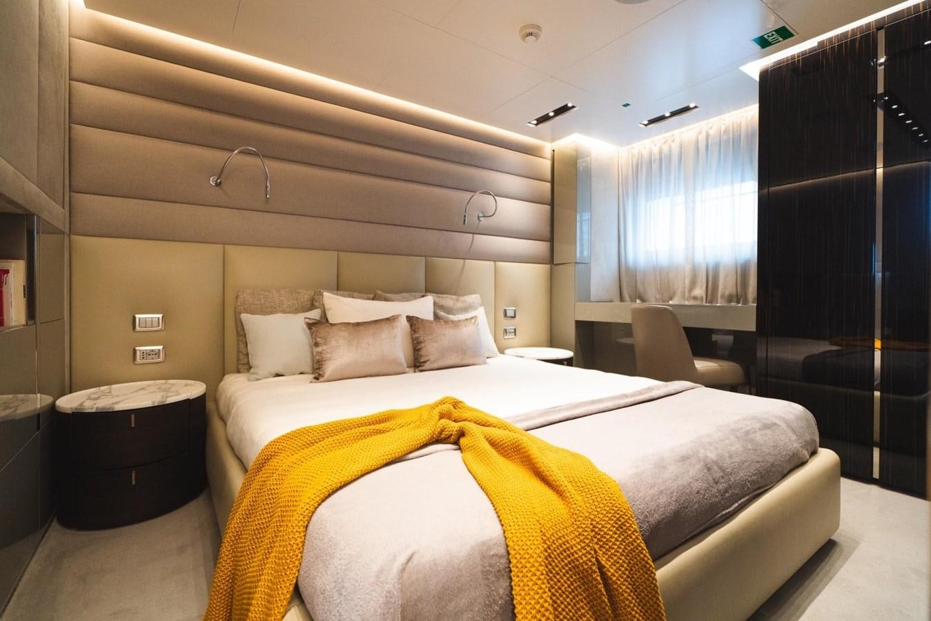a bed with a yellow blanket aboard JESMA II Yacht for Charter