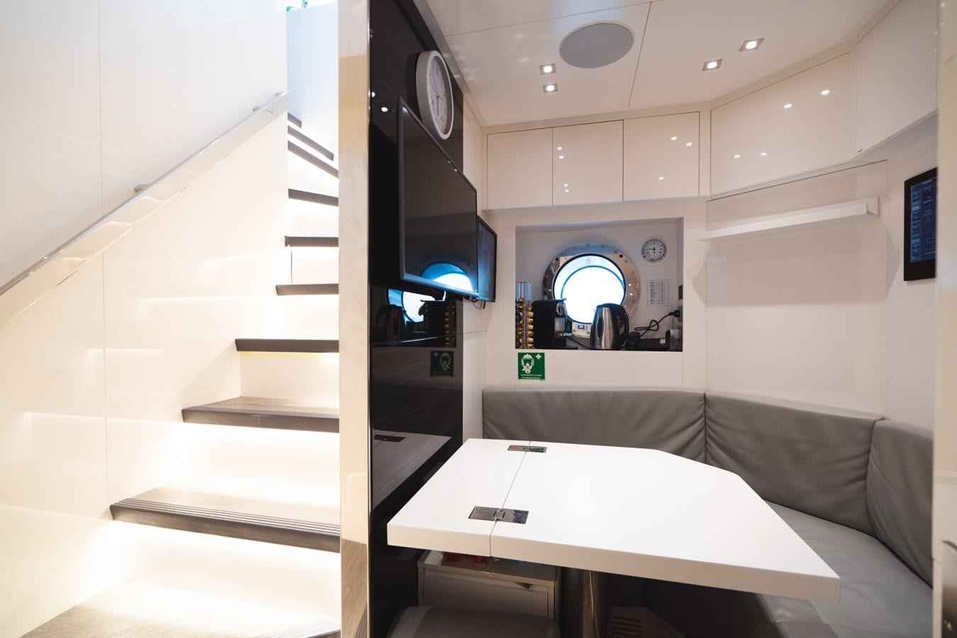 a room with a table and a tv aboard JESMA II Yacht for Charter
