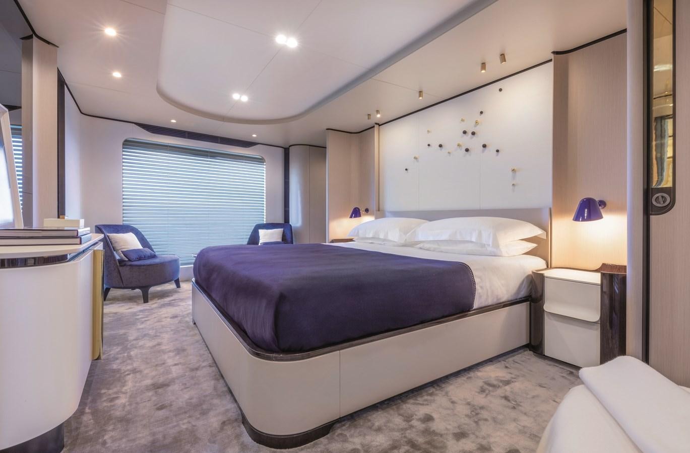 a bedroom with a bed and a chair aboard LA MAMA Yacht for Sale