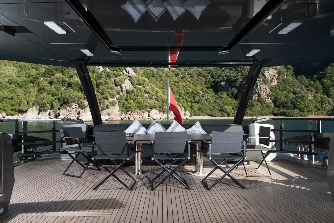 a patio with chairs and tables aboard FX Yacht for Sale