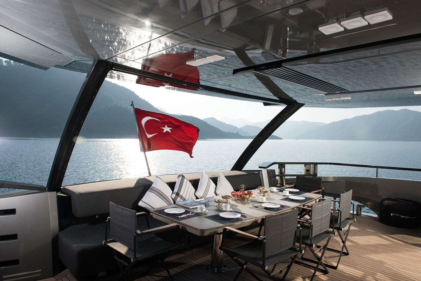a room with tables and chairs aboard FX Yacht for Sale