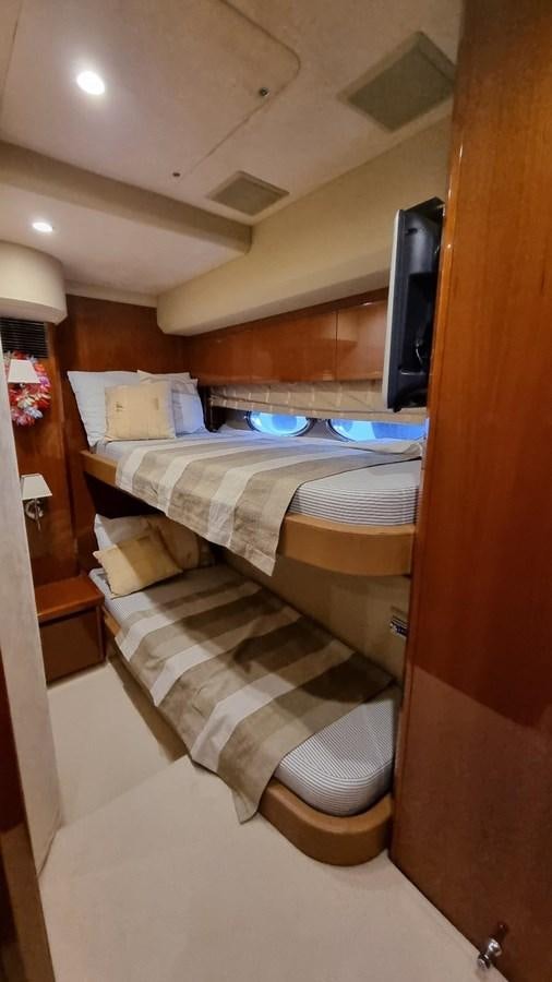 a bed with a television on the wall aboard SERENA Yacht for Sale