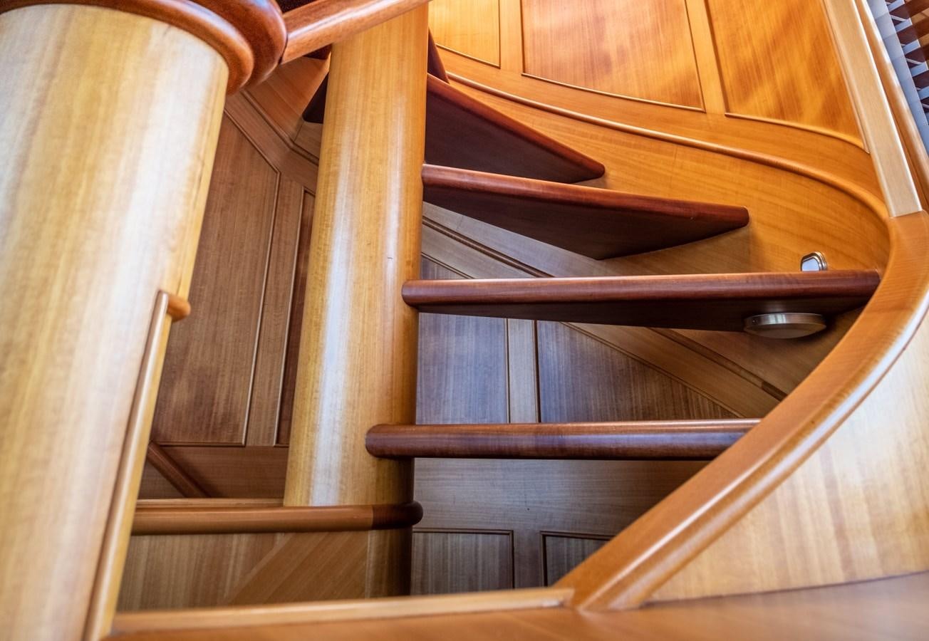 a wooden staircase with a metal railing aboard FORTUNA Yacht for Sale