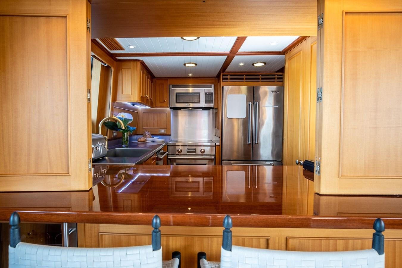 a kitchen with wooden cabinets aboard FORTUNA Yacht for Sale