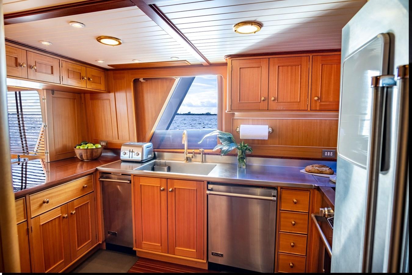a kitchen with wooden cabinets aboard FORTUNA Yacht for Sale