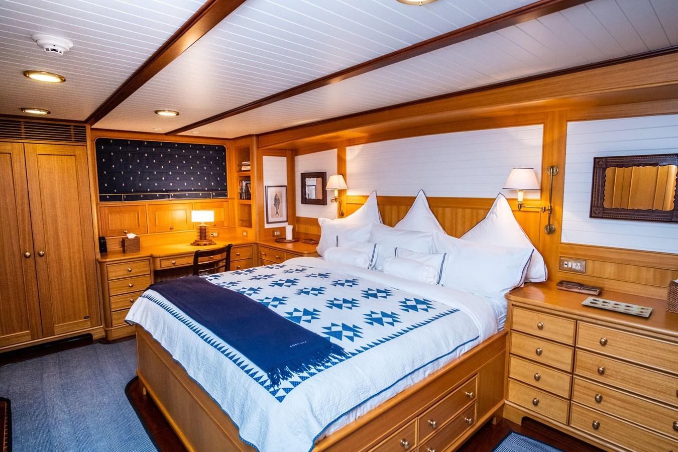 a bedroom with a bed and a dresser aboard FORTUNA Yacht for Sale
