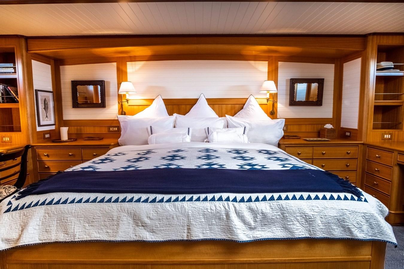 a bed with a blue sheet aboard FORTUNA Yacht for Sale