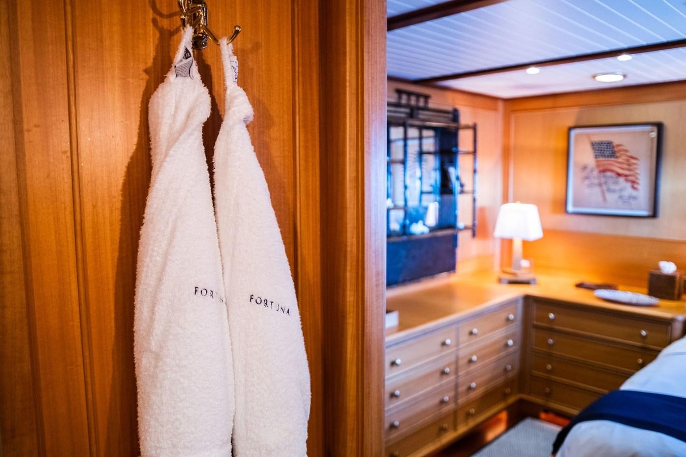 a white sheet on a swinger in a room with a dresser and a mirror aboard FORTUNA Yacht for Sale