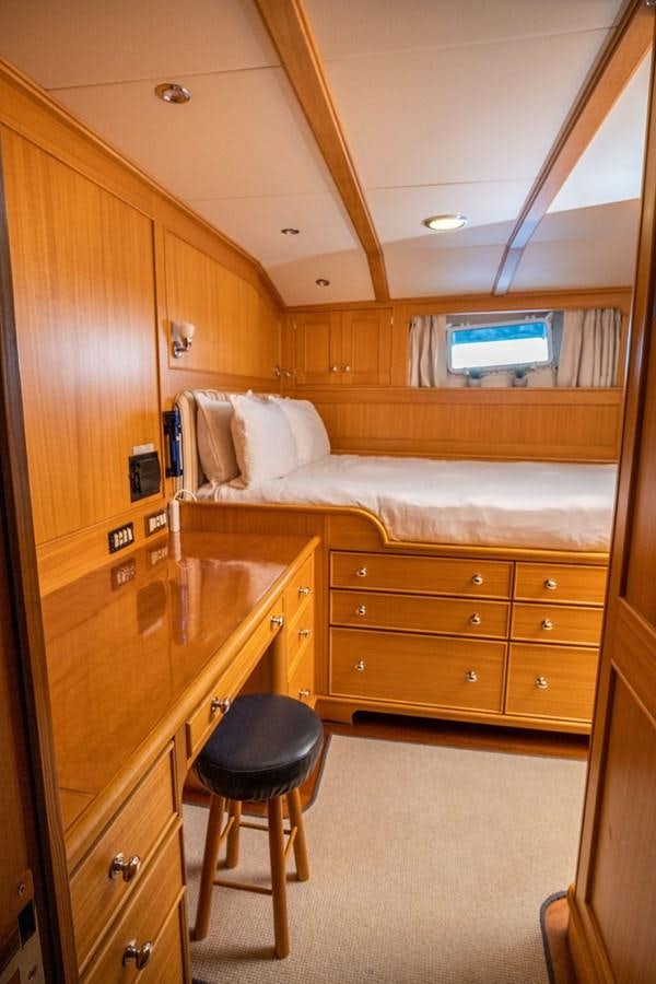 a bedroom with a bed and desk aboard FORTUNA Yacht for Sale