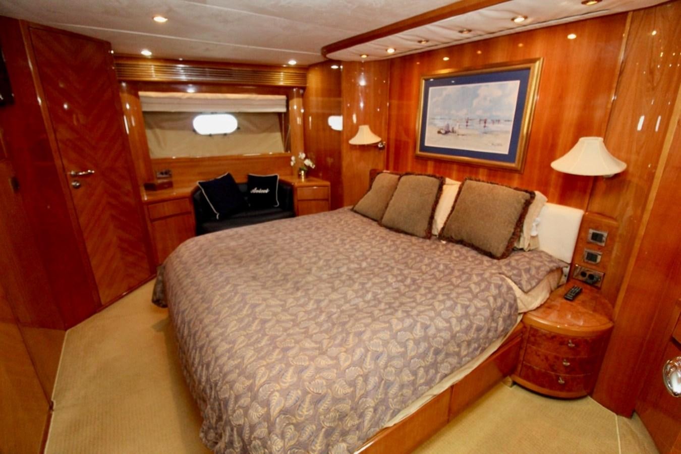 a bedroom with a bed and a chair aboard AVICCI Yacht for Sale