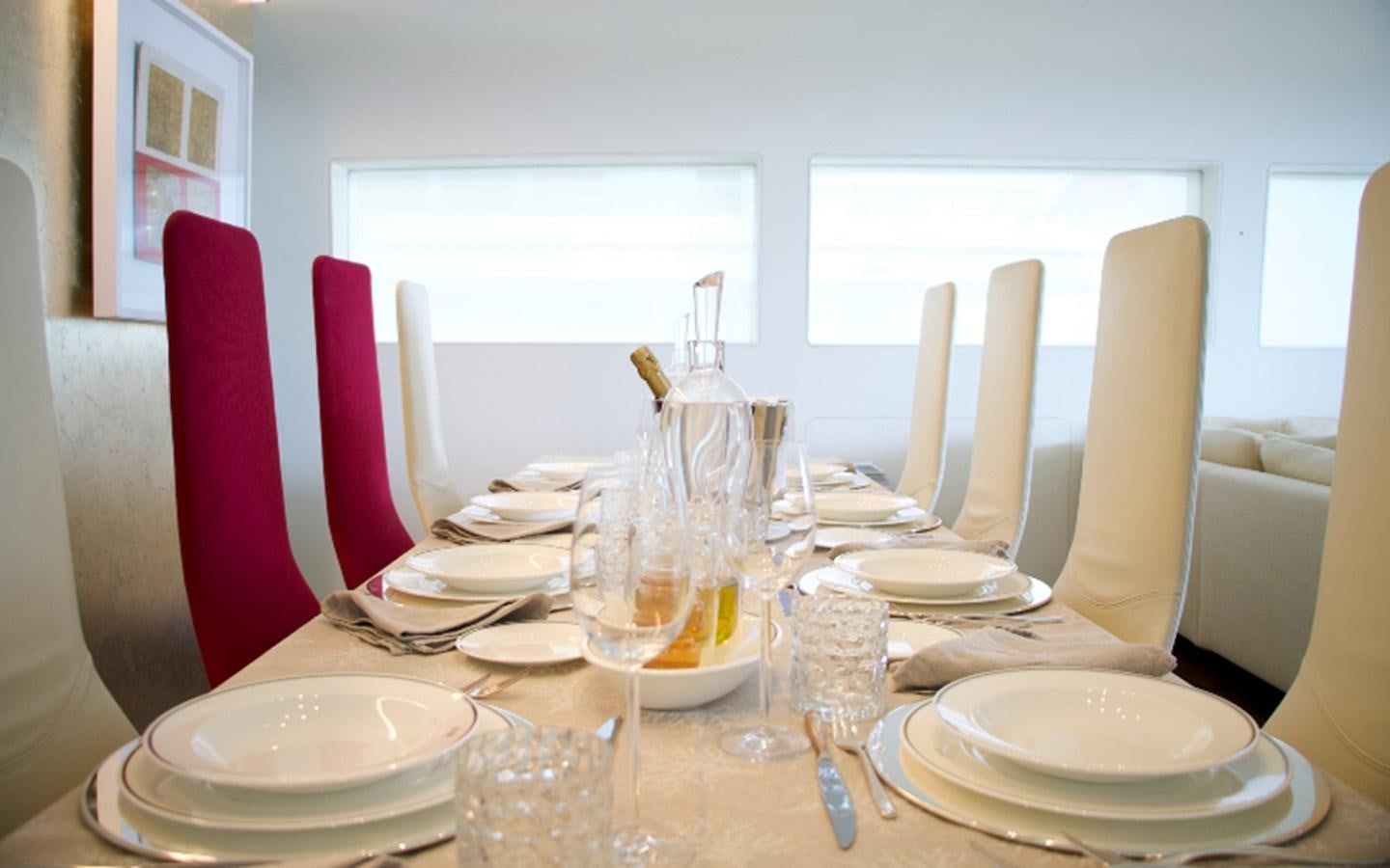 a table set with plates and glasses aboard PAB Yacht for Sale
