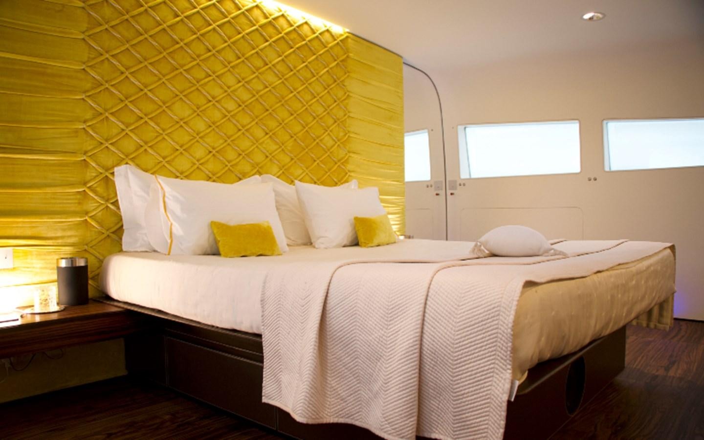 a bed with yellow sheets aboard PAB Yacht for Sale