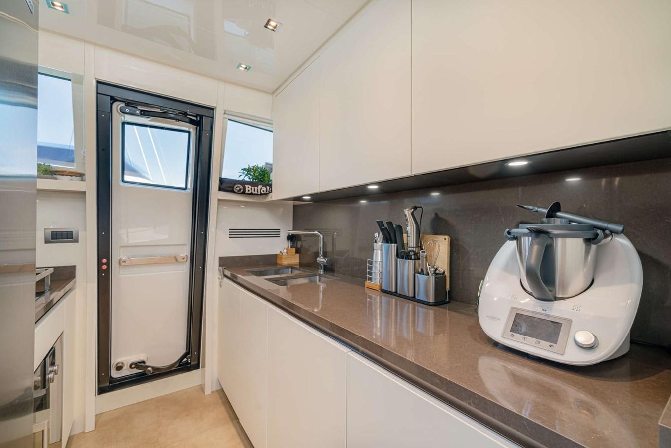 a kitchen with a stainless steel refrigerator aboard LUCKY Yacht for Sale