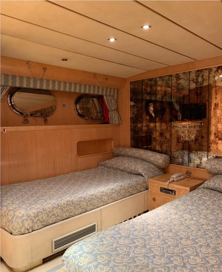 a bedroom with a bed and a fireplace aboard BAHIRA II Yacht for Sale