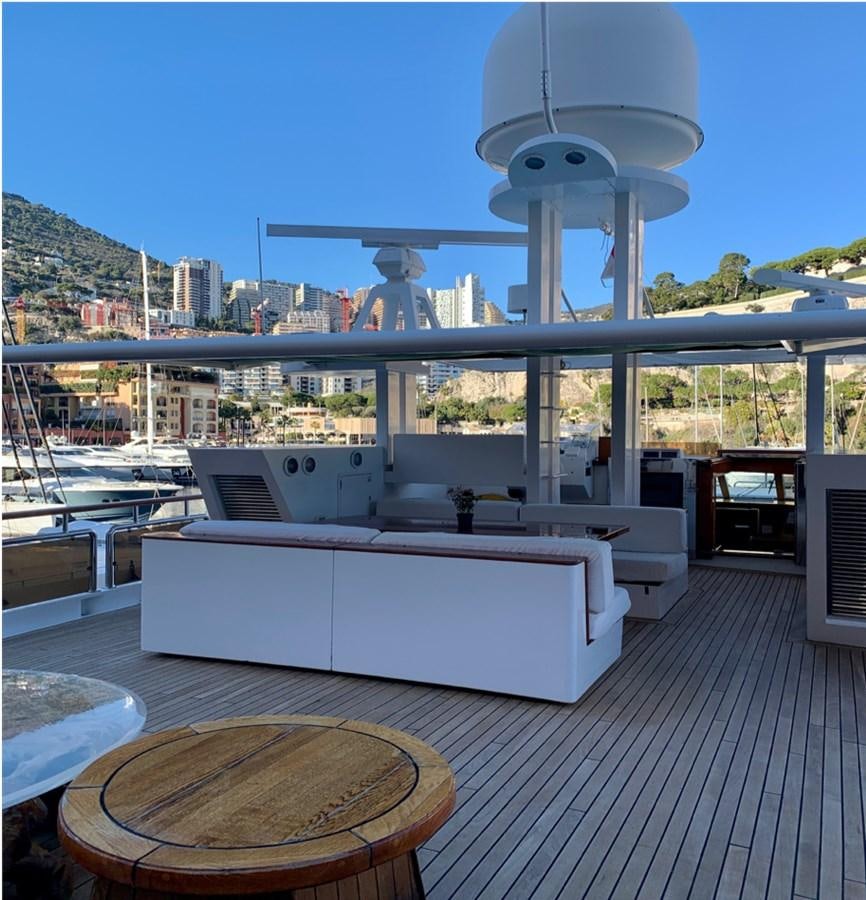 a large white lounge chair on a deck overlooking a city aboard BAHIRA II Yacht for Sale