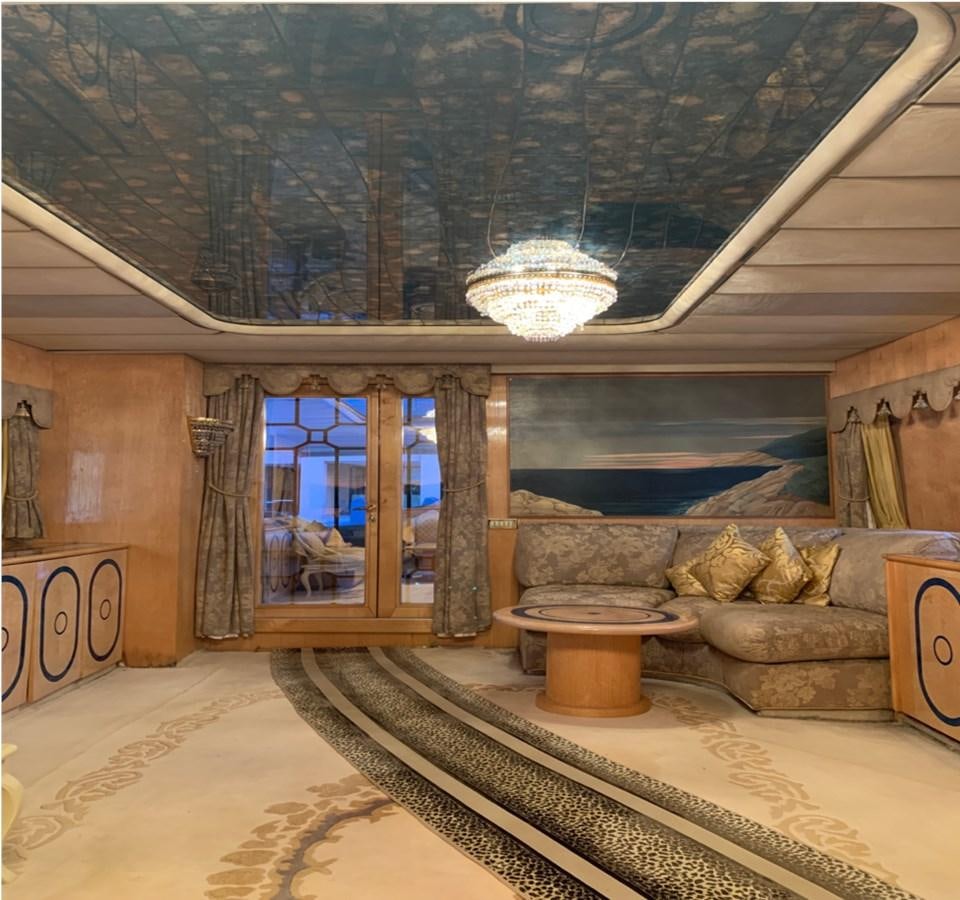 a room with a large window and a large stone fireplace aboard BAHIRA II Yacht for Sale