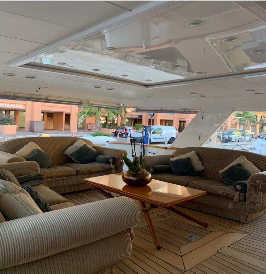 a living room with a table and couches aboard BAHIRA II Yacht for Sale