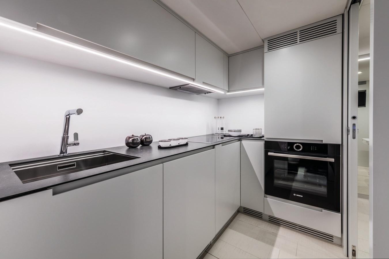 a kitchen with white cabinets aboard PERSHING 8X   Yacht for Sale