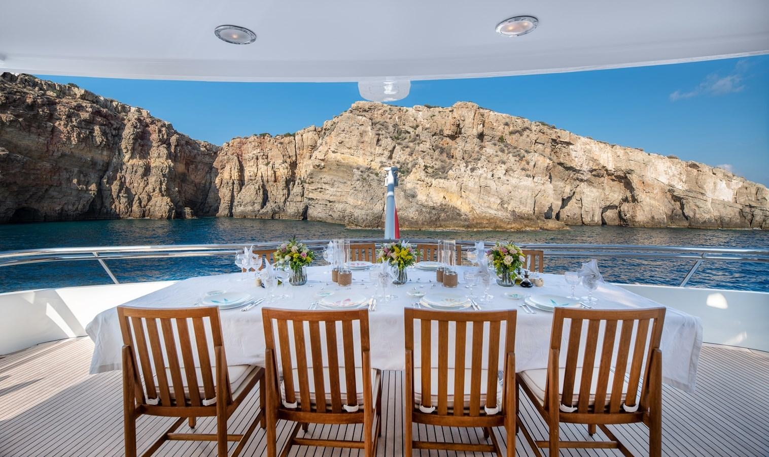 a table with chairs on it by a pool of water aboard IRAVATI Yacht for Sale