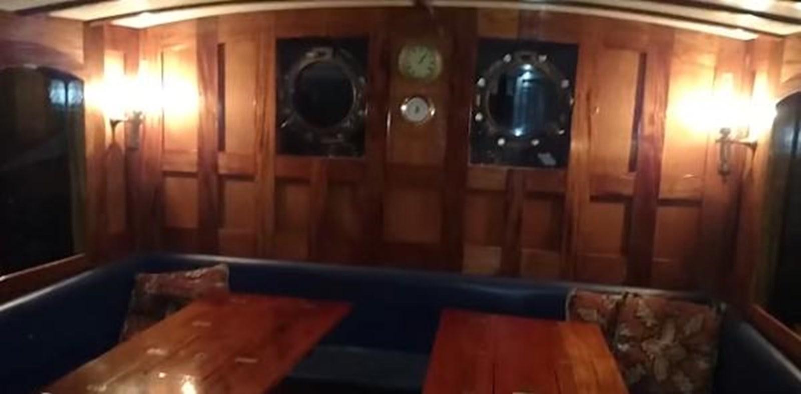 a room with a table and a tv on the wall aboard 1963 TRAWLER DE HASS NORTH SEA, WANDERBIRD  Yacht for Sale