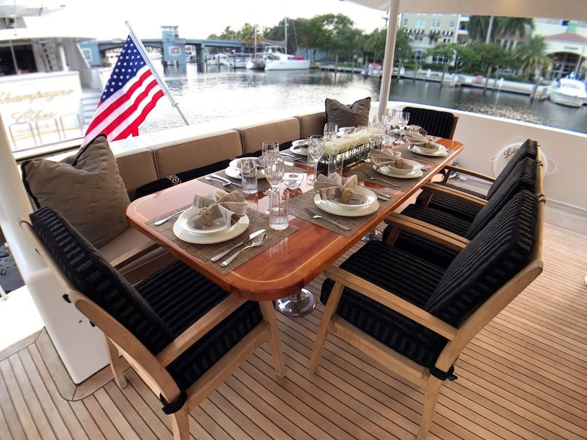 a table with chairs and a flag on it aboard HARBOR LADY Yacht for Sale
