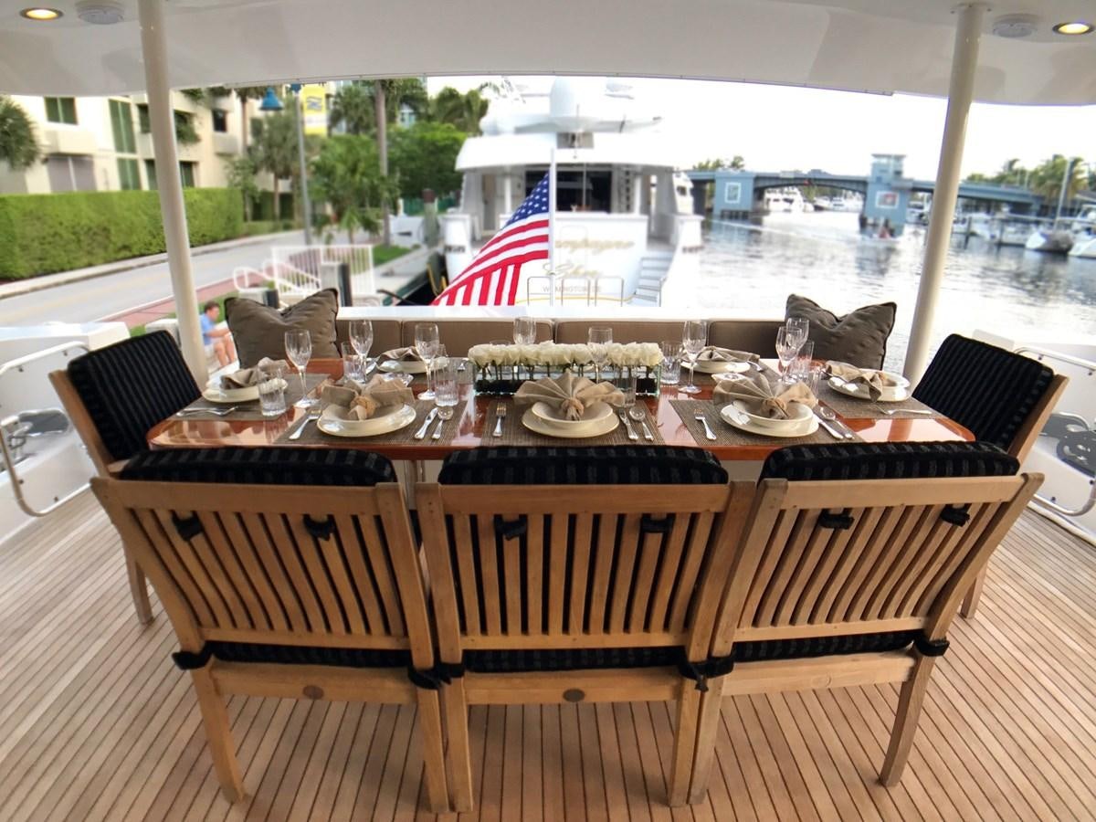 a table with chairs and a flag aboard HARBOR LADY Yacht for Sale
