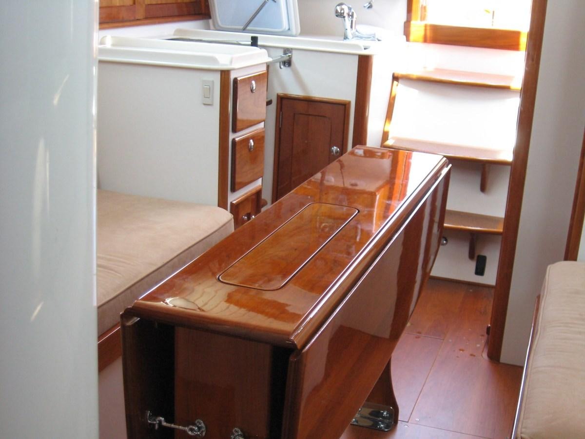 a kitchen with a table and cabinets aboard BOADICEA Yacht for Sale