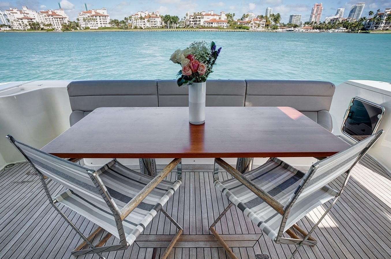 a table with flowers on it by the water aboard Mojo Yacht for Sale