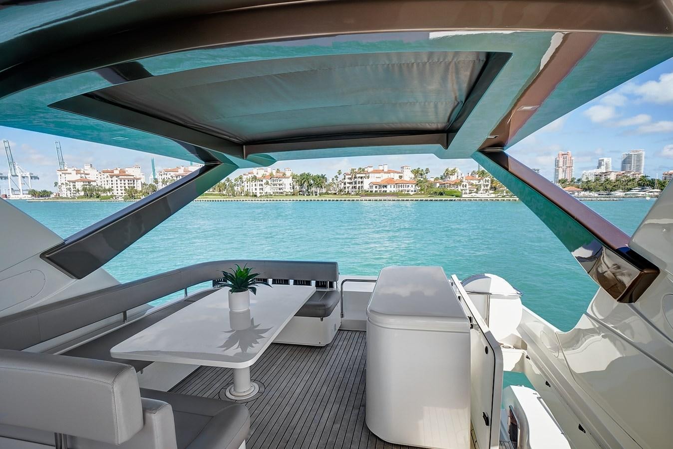 a room with a table chairs and a plant on the table aboard Mojo Yacht for Sale