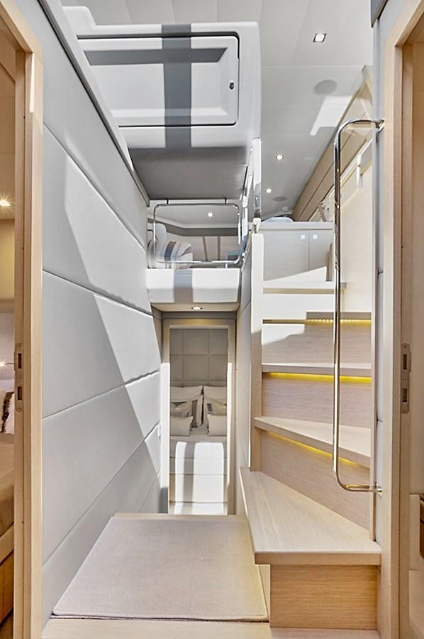 a room with a glass door and a metal railing aboard Mojo Yacht for Sale