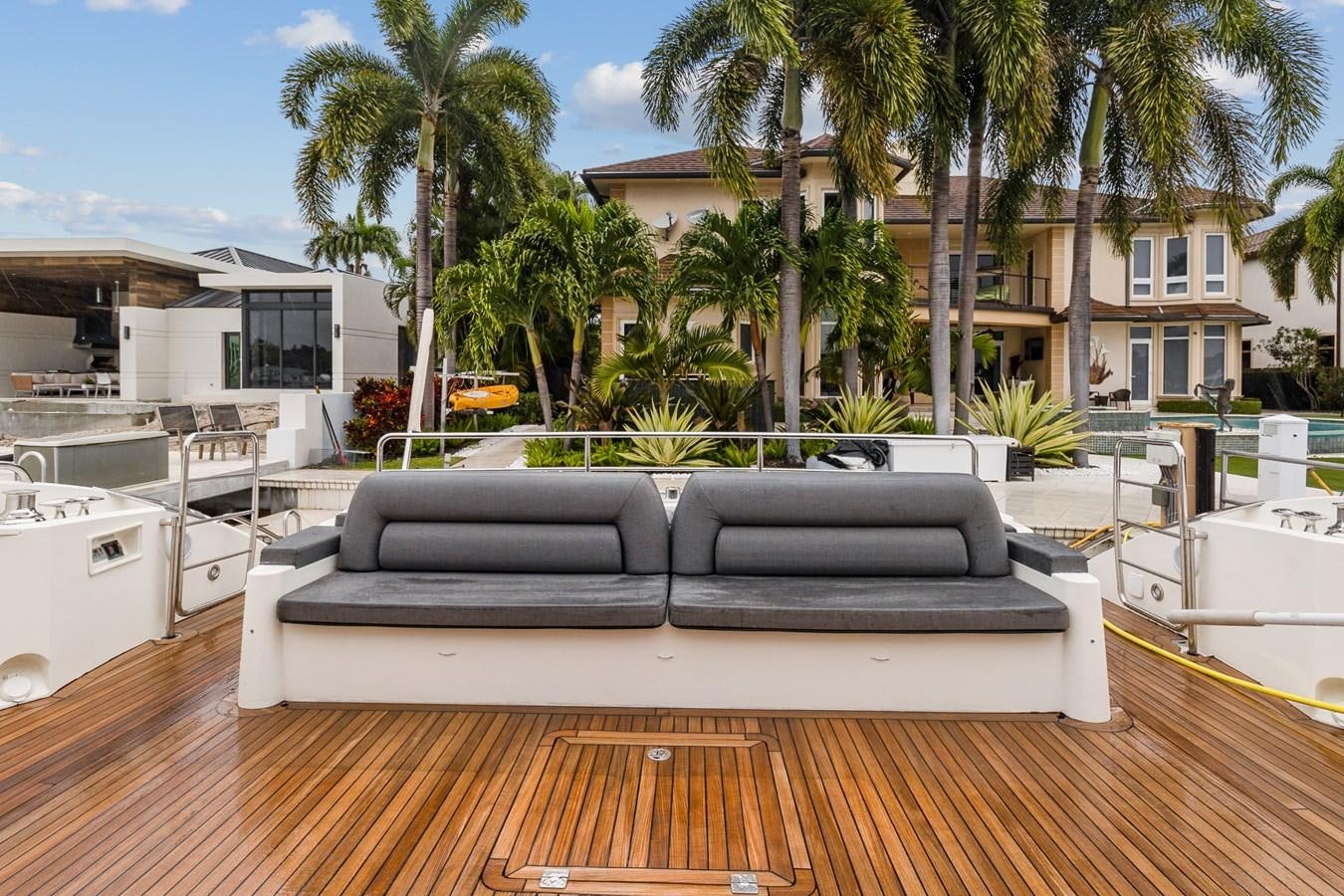 a deck with a pool and palm trees on the side aboard HER WAY Yacht for Sale